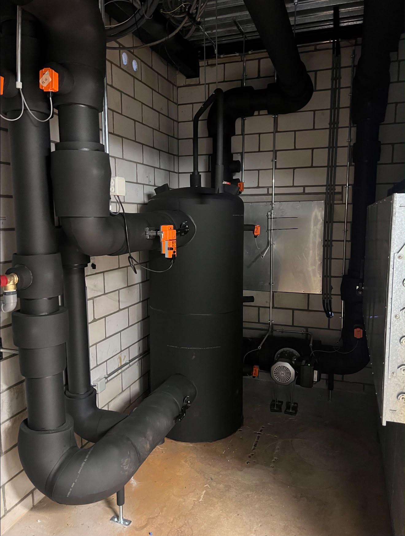 Technische leidingisolatie in een installatieruimte met zwarte elastomeer isolatie